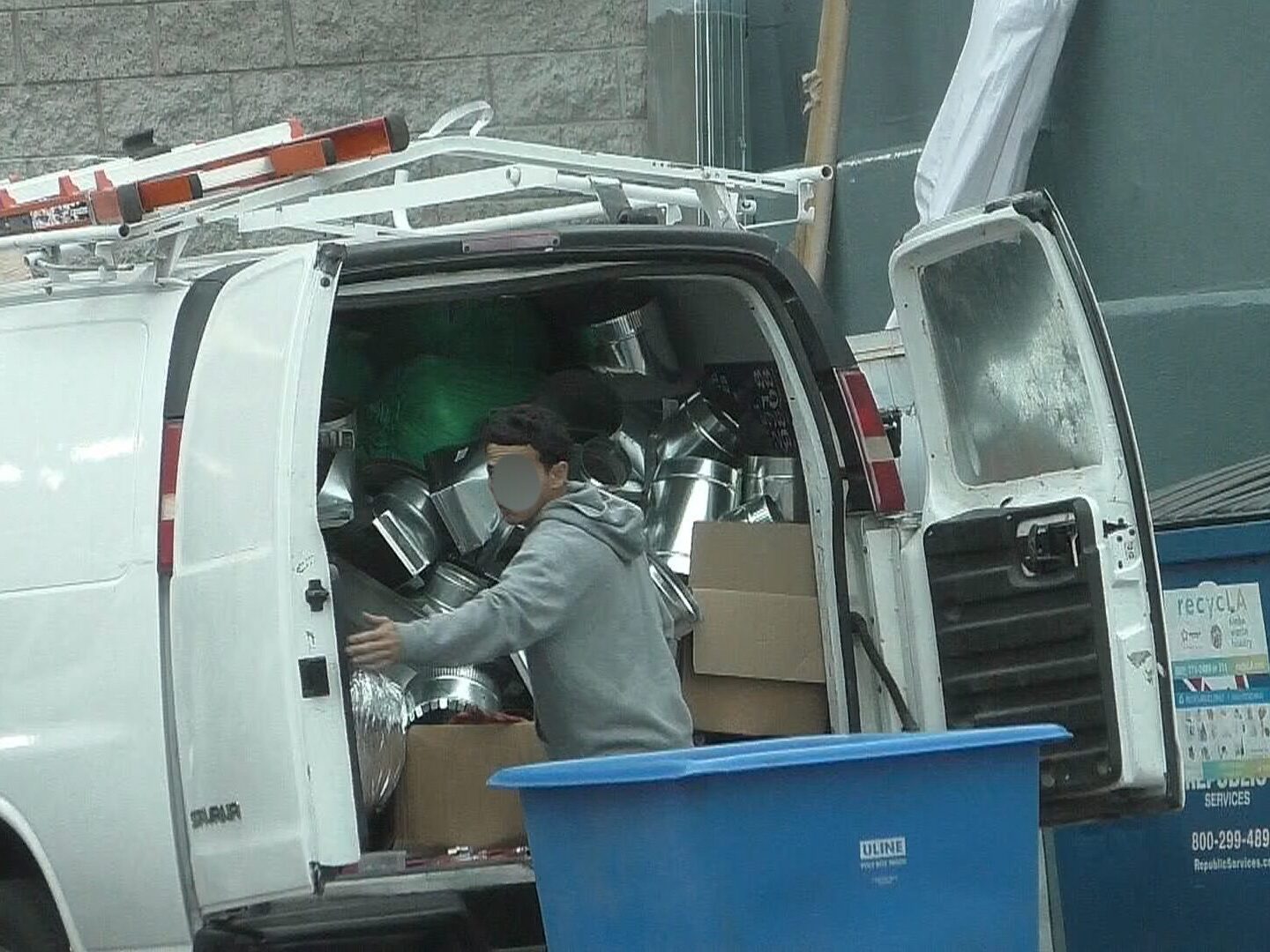 Workers compensation suspected fraudster caught working. Young man showing up to work and unloading work van.
